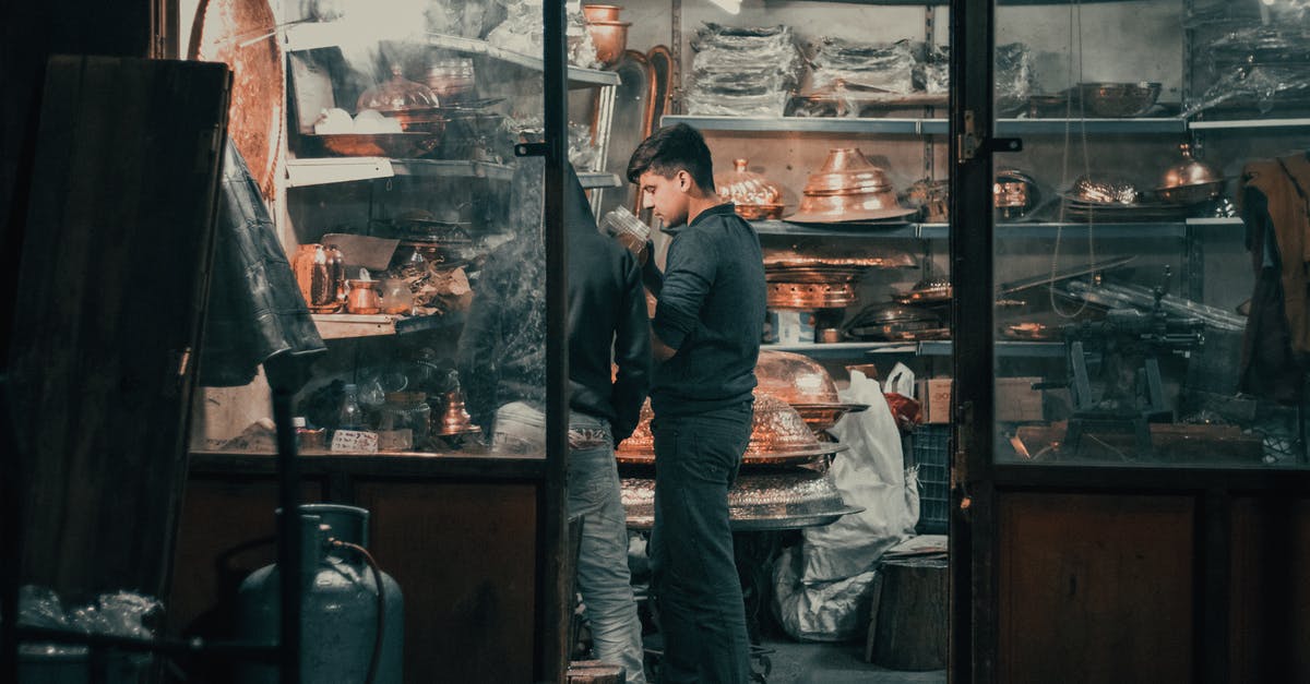 Business Travel on Client expenses - Young ethnic man working in traditional oriental store Business Travel on Client expenses - Young ethnic man working in traditional oriental store