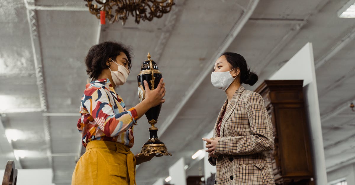 Business Travel on Client expenses - A Woman Showing an Antique Jar to Another Woman Business Travel on Client expenses - A Woman Showing an Antique Jar to Another Woman