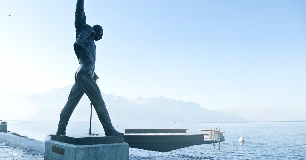 Butterfly Hunting in Montreux Switzerland - Gray Metal Statue of Man Raising Hand Near Dock Butterfly Hunting in Montreux Switzerland - Gray Metal Statue of Man Raising Hand Near Dock