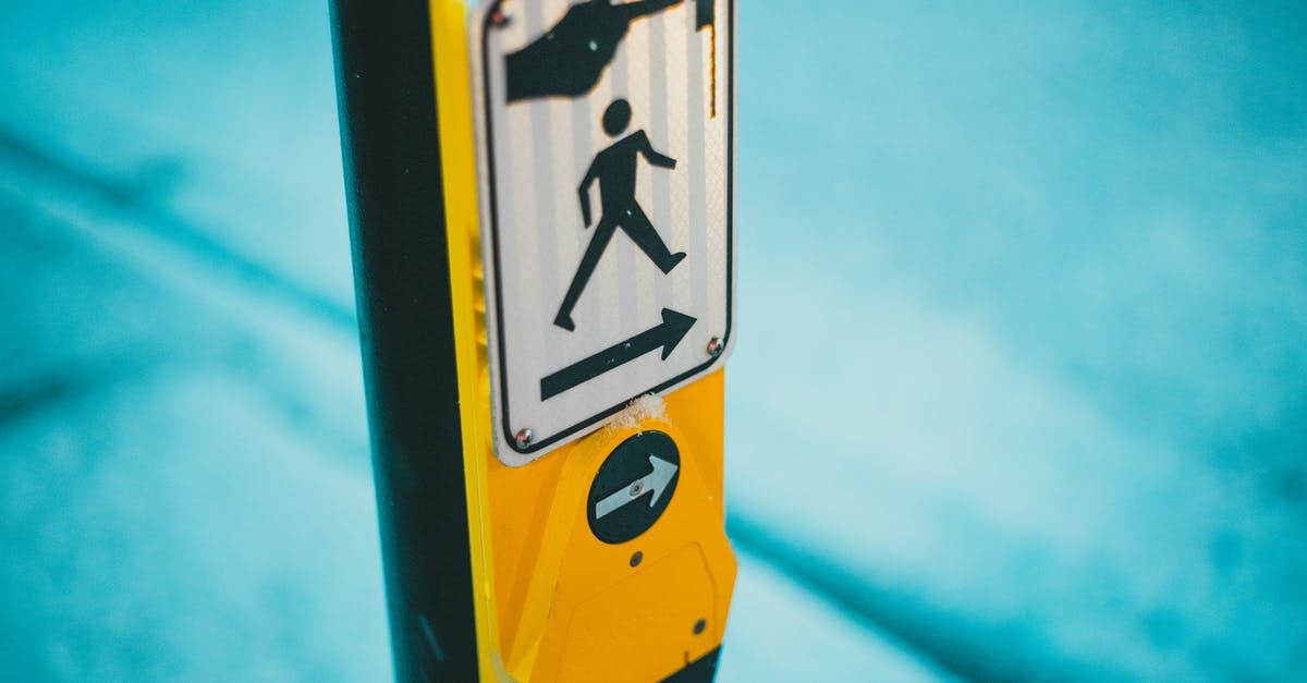 Button for pedestrian traffic lights in Germany - Selective focus of blind and deaf friendly pedestrian crosswalk control button for changing traffic lights and crossing street on zebra in traffic with sign on street Button for pedestrian traffic lights in Germany - Selective focus of blind and deaf friendly pedestrian crosswalk control button for changing traffic lights and crossing street on zebra in traffic with sign on street