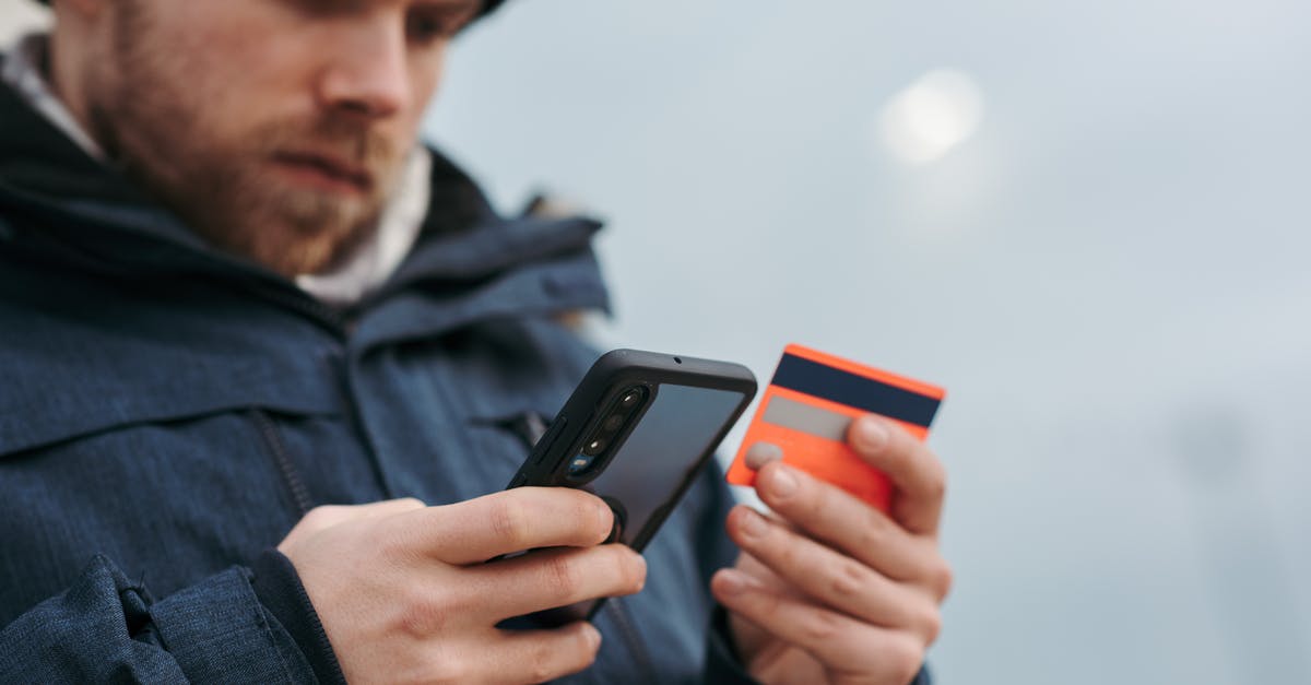 Buy mobile data in Morocco with Inwi SIM card - Serious man paying online purchases using smartphone on street Buy mobile data in Morocco with Inwi SIM card - Serious man paying online purchases using smartphone on street