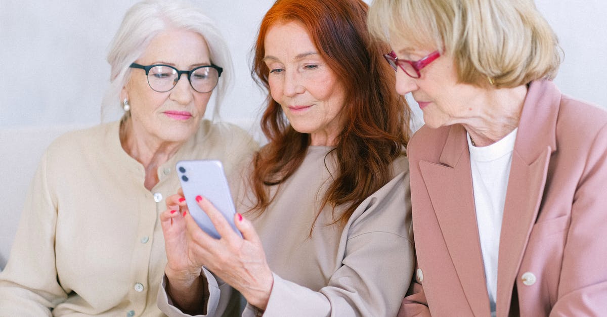 Buy smartphone in US while visiting, fees in Europe - Aged women using smartphone together