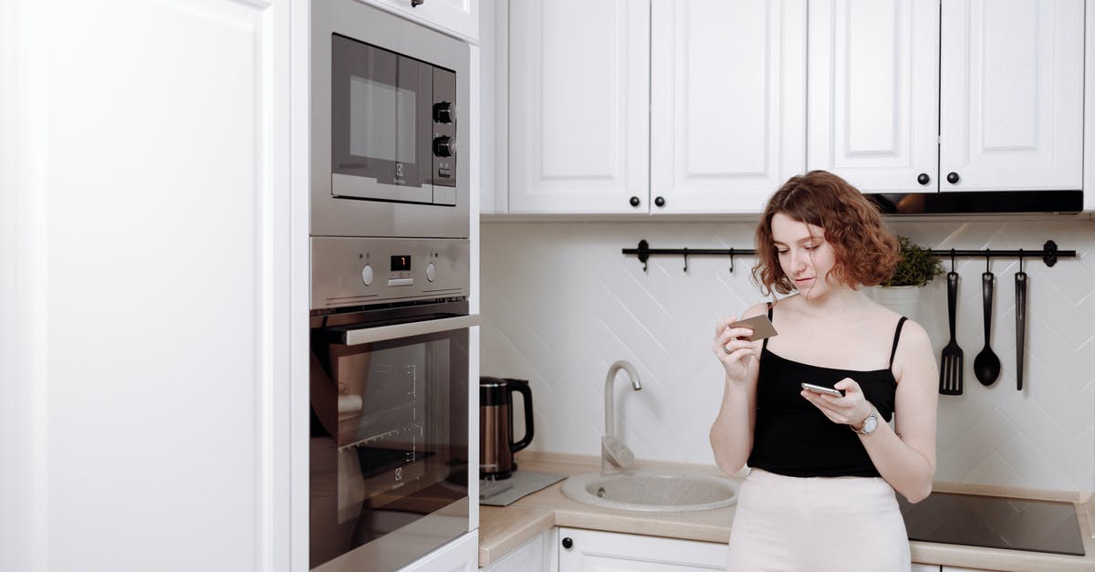 Buying a phone in the US - Woman Leaning on a Kitchen Counter Buying a phone in the US - Woman Leaning on a Kitchen Counter