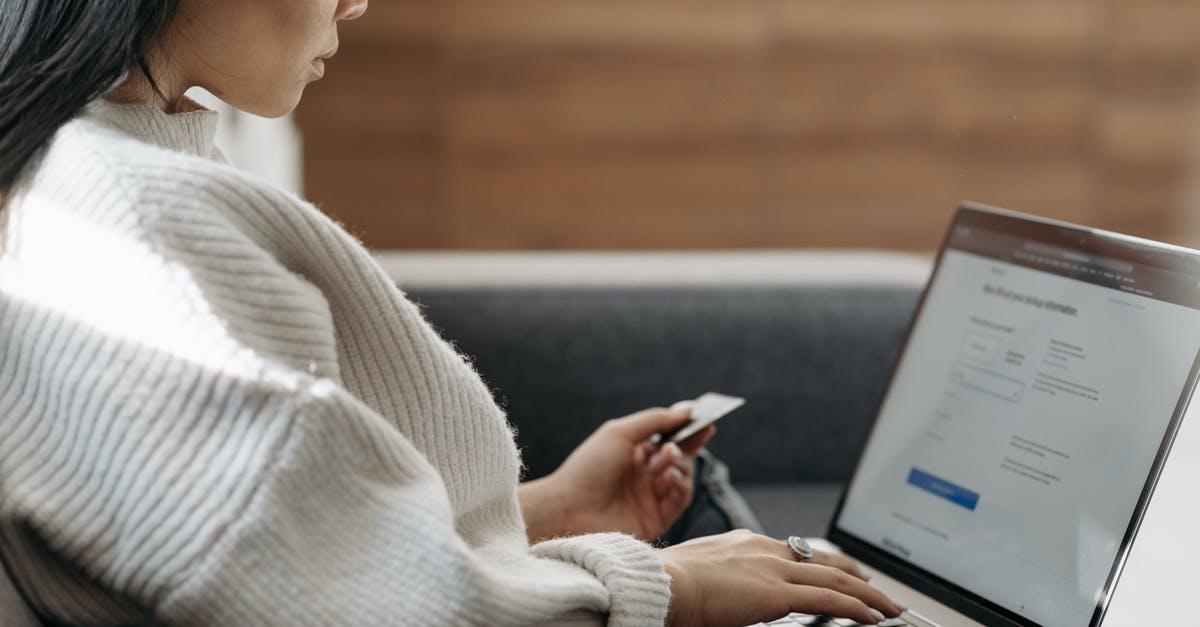 Buying a SIM card on arrival in Amsterdam - Woman in White Sweater Entering Card Details into Laptop Buying a SIM card on arrival in Amsterdam - Woman in White Sweater Entering Card Details into Laptop