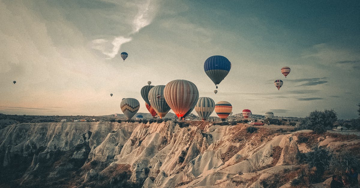 Buying flight ticket but in different situation - Assorted air balloons flying above sandy mountains Buying flight ticket but in different situation - Assorted air balloons flying above sandy mountains