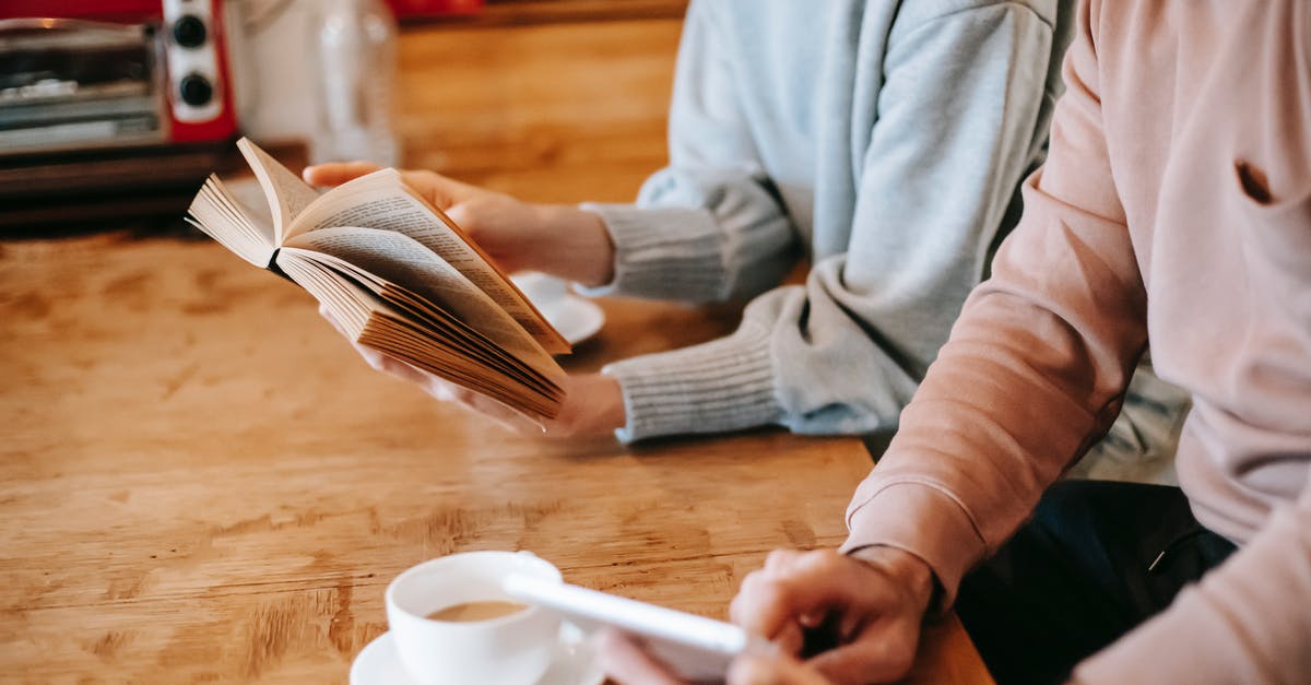 Buying goods online from Canada to EU is VAT free? [closed] - From above of crop faceless spouses in casual clothes using tablet and reading book while sitting at wooden table with cups of cappuccino at home