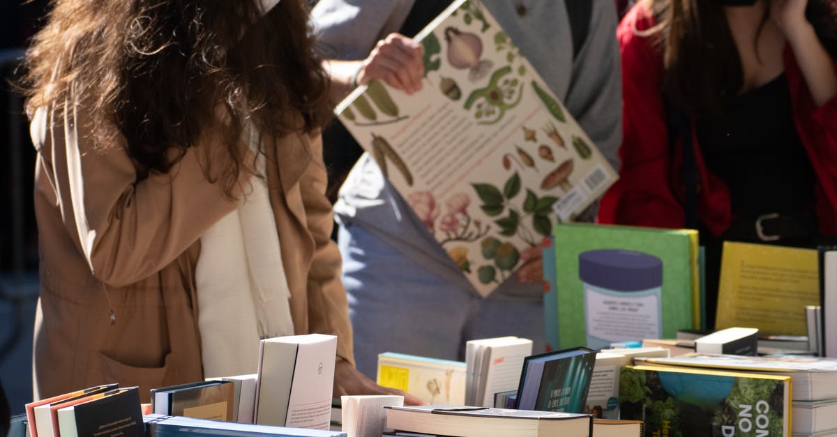 Buying Holi accessories after the event has ended - People Looking at Books Buying Holi accessories after the event has ended - People Looking at Books