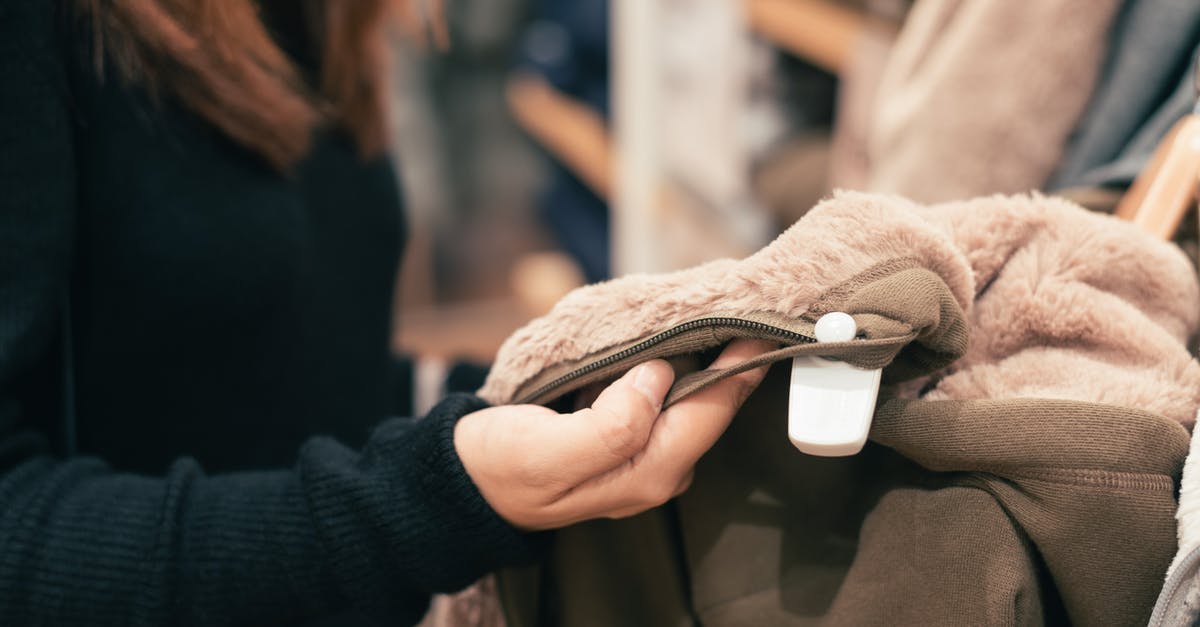 Buying tickets for New York Yankees game - Woman Wearing Black Sweater Holding Fleece Cloth Buying tickets for New York Yankees game - Woman Wearing Black Sweater Holding Fleece Cloth