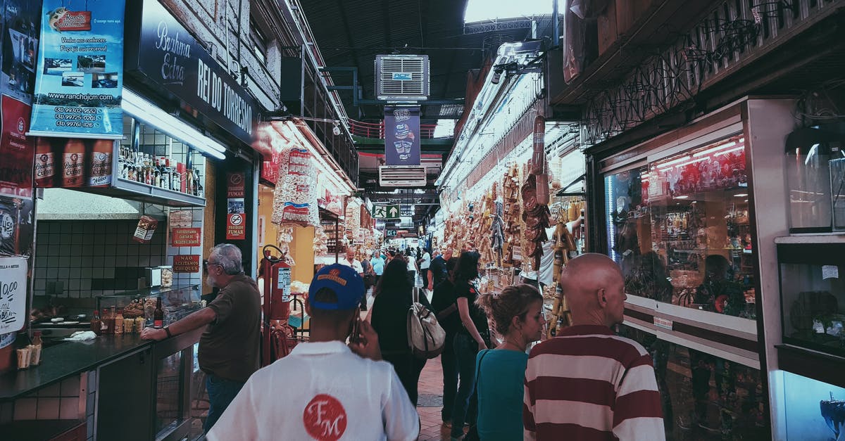 Buying Travel Insurance Whilst Abroad (UK Citizen) - People Shopping At Stores In An Alley Buying Travel Insurance Whilst Abroad (UK Citizen) - People Shopping At Stores In An Alley