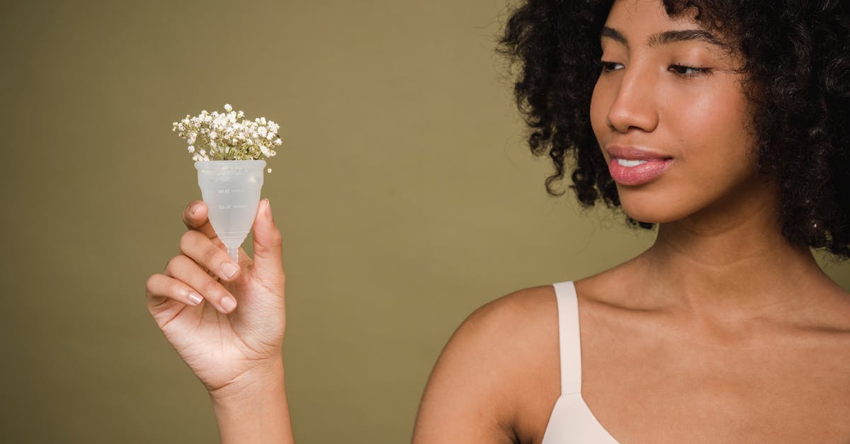 C-1 Visa validity period after issuance - Happy young African American female model with curly hair in bra smiling and showing menstrual cup with gentle flowers against beige background C-1 Visa validity period after issuance - Happy young African American female model with curly hair in bra smiling and showing menstrual cup with gentle flowers against beige background