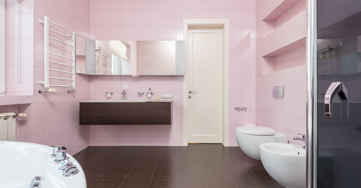 Cabin luggage on Australian domestic flights - Interior of modern bathroom in pink and brown colors with white bathtub and glass shower cabin and mirror hanging on wall Cabin luggage on Australian domestic flights - Interior of modern bathroom in pink and brown colors with white bathtub and glass shower cabin and mirror hanging on wall