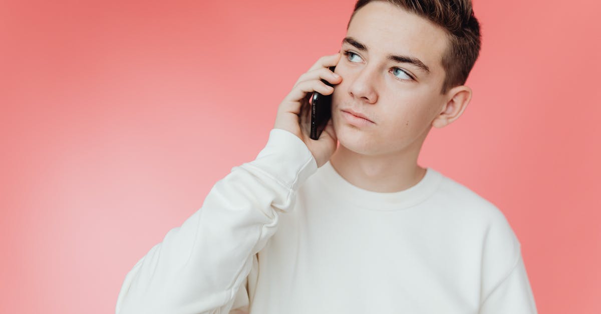Calling within Europe - Man in White Crew Neck Long Sleeve Shirt Holding Black Smartphone Calling within Europe - Man in White Crew Neck Long Sleeve Shirt Holding Black Smartphone
