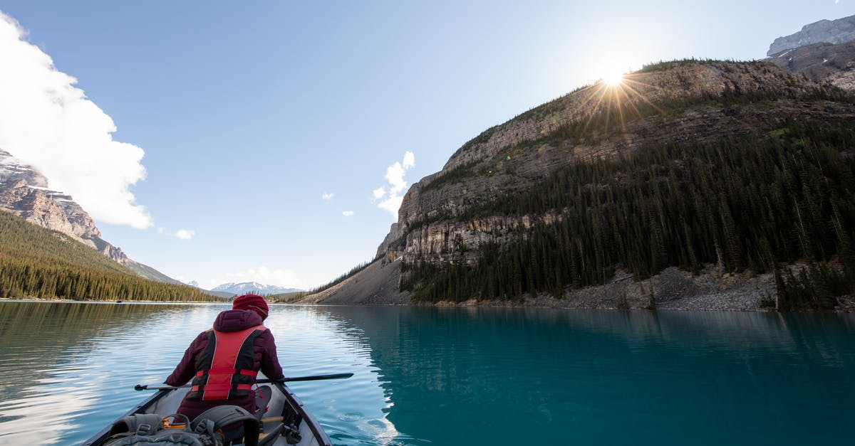 Camping in French National Parks - Person Riding Boat in Body of Water Between Islands Camping in French National Parks - Person Riding Boat in Body of Water Between Islands