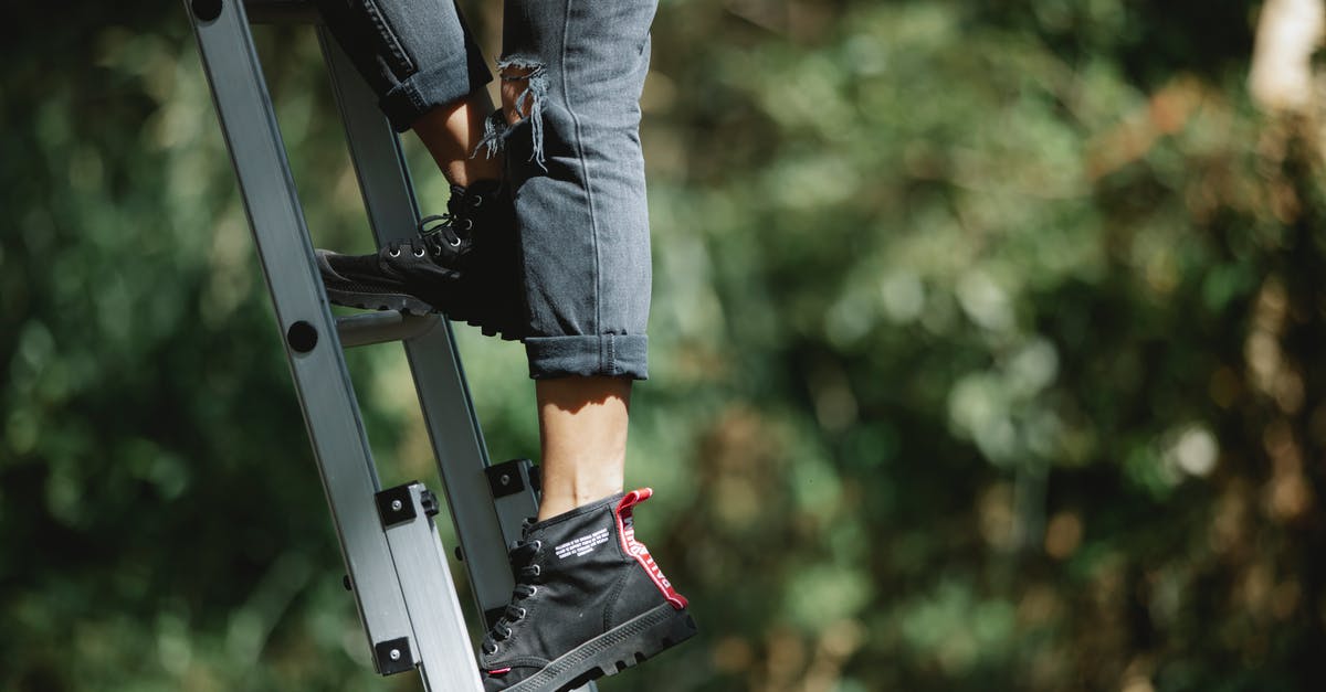 Camping safety in the Everglades in May - Faceless camper climbing ladder in forest Camping safety in the Everglades in May - Faceless camper climbing ladder in forest