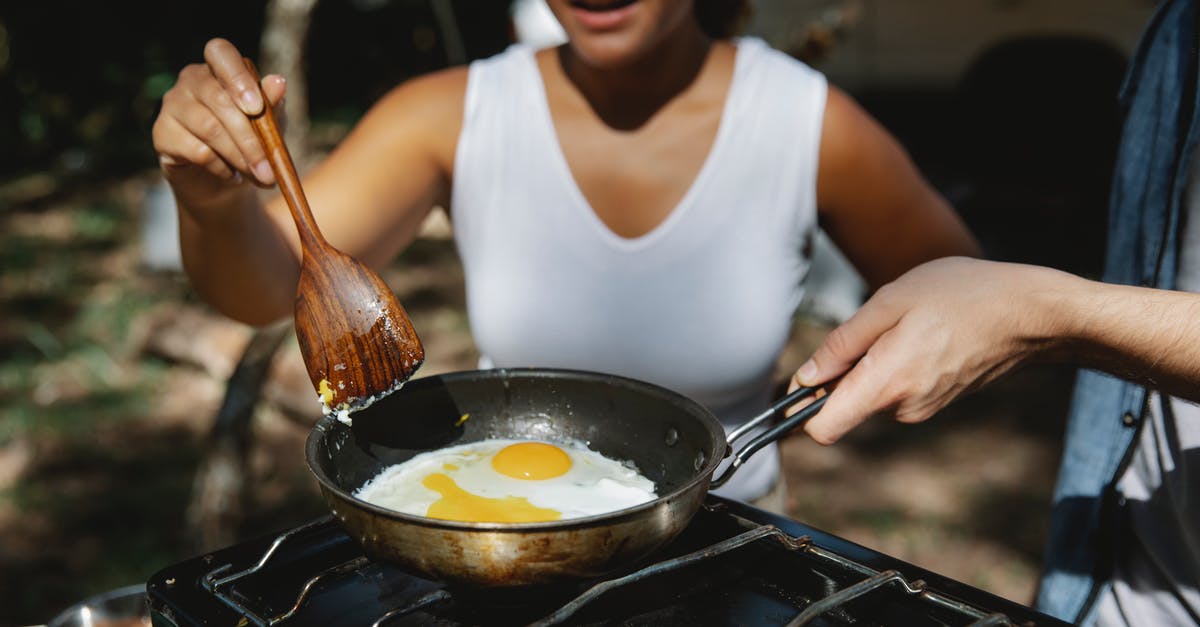 Camping stove on a plane? - Crop diverse couple cooking eggs on skillet Camping stove on a plane? - Crop diverse couple cooking eggs on skillet