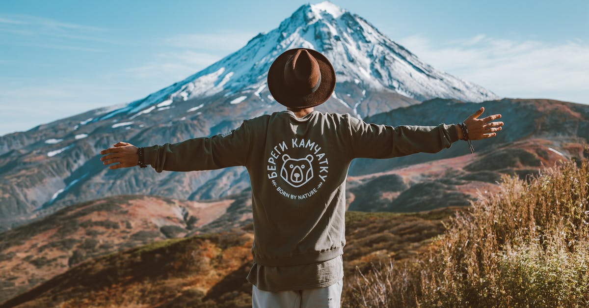 Can a 15-year-old travel alone to Russia from the USA? - Lonely traveller in hat admiring distant mountain Can a 15-year-old travel alone to Russia from the USA? - Lonely traveller in hat admiring distant mountain