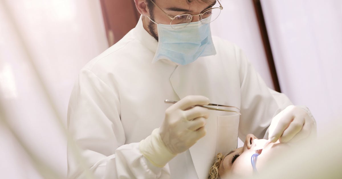 Can a D.O. sign the medical certificate for a student visa at the Chicago consulate? [closed] - Man in White Long Sleeve Shirt Holding a Dental Tool