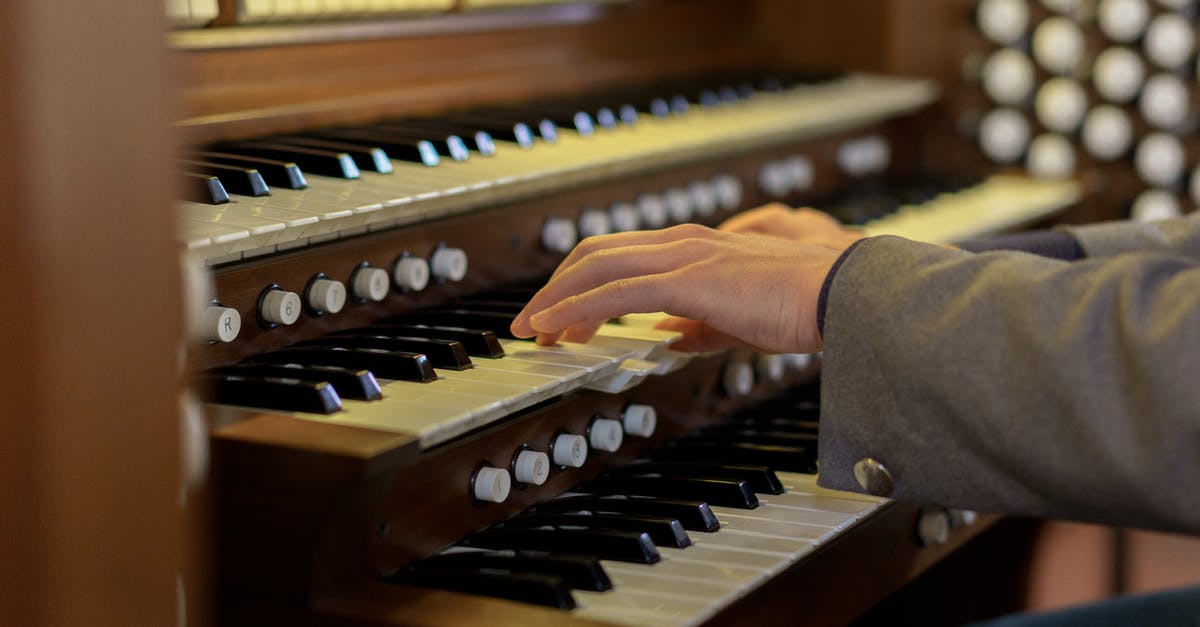 Can a musician bring his used electronic organ to Indonesia [closed] - Close-Up Shot of a Person Playing Piano