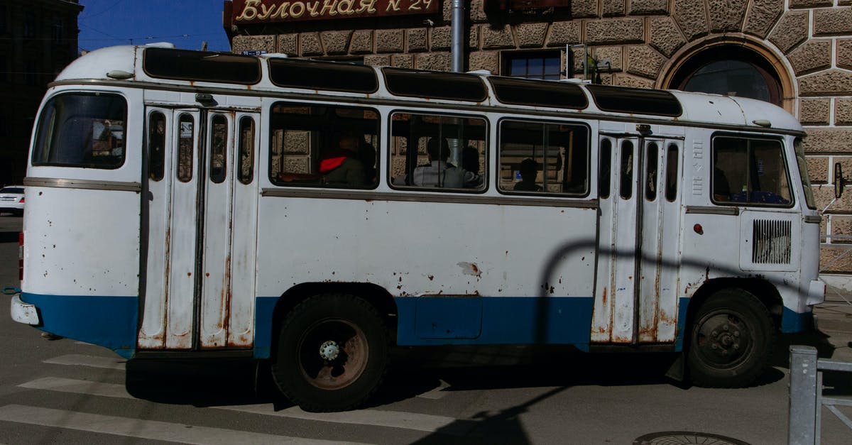 Can a person with dutch residence permit drive with non-eu driving license in Belgium? [closed] - Old fashioned rusty bus with people driving on intersection at corner of city street