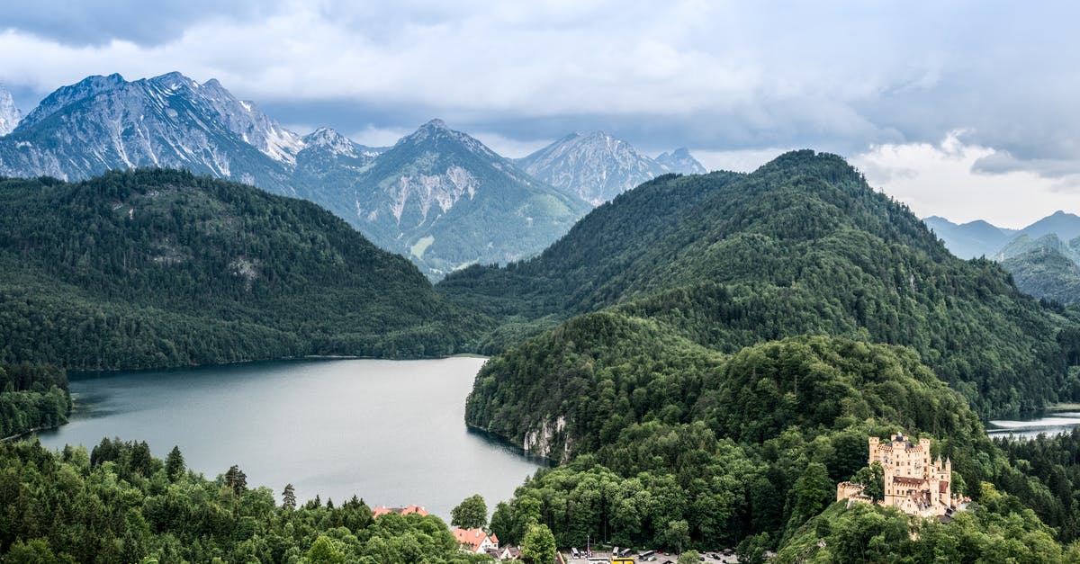 Can a Syrian citizen, who holds a USA green card, travel through Germany without a visa? [closed] - Green Mountains Near River Under Blue Sky