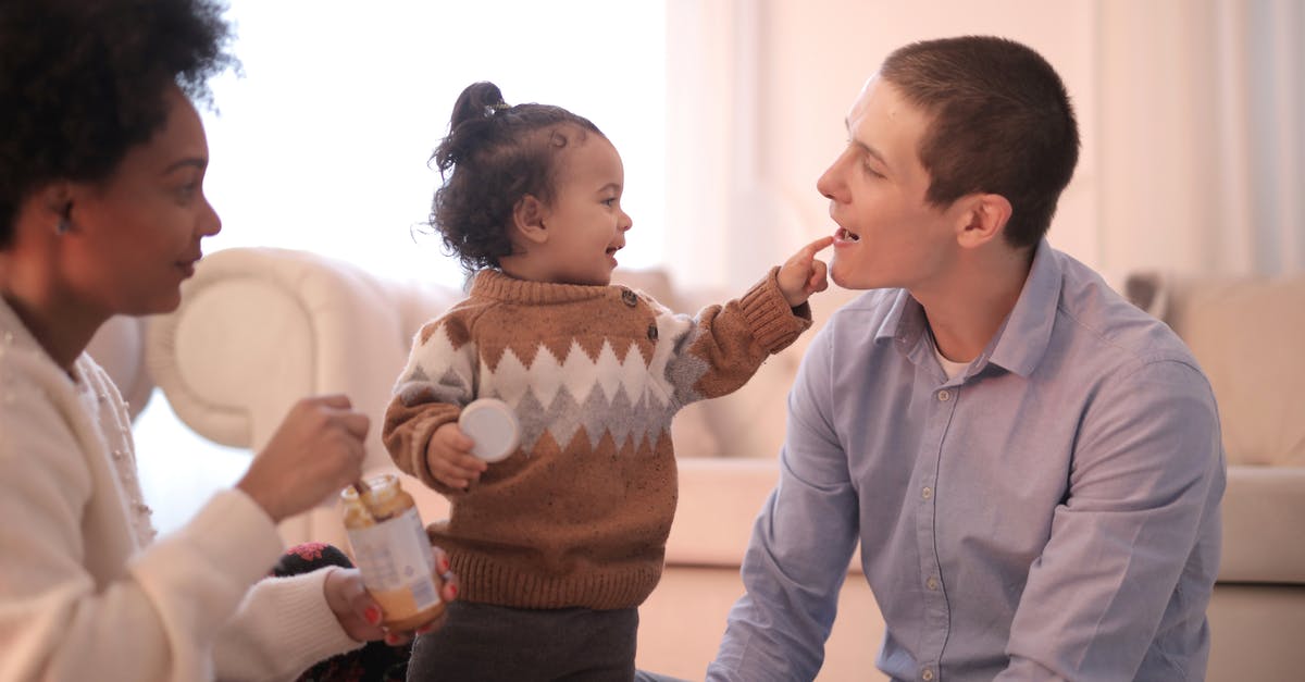 Can American mother living in France bring French father with her to the US right now? [duplicate] - Side view of diverse parents in casual clothing sitting on floor and having fun with smiling toddler while gathering in cozy living room and having rest together