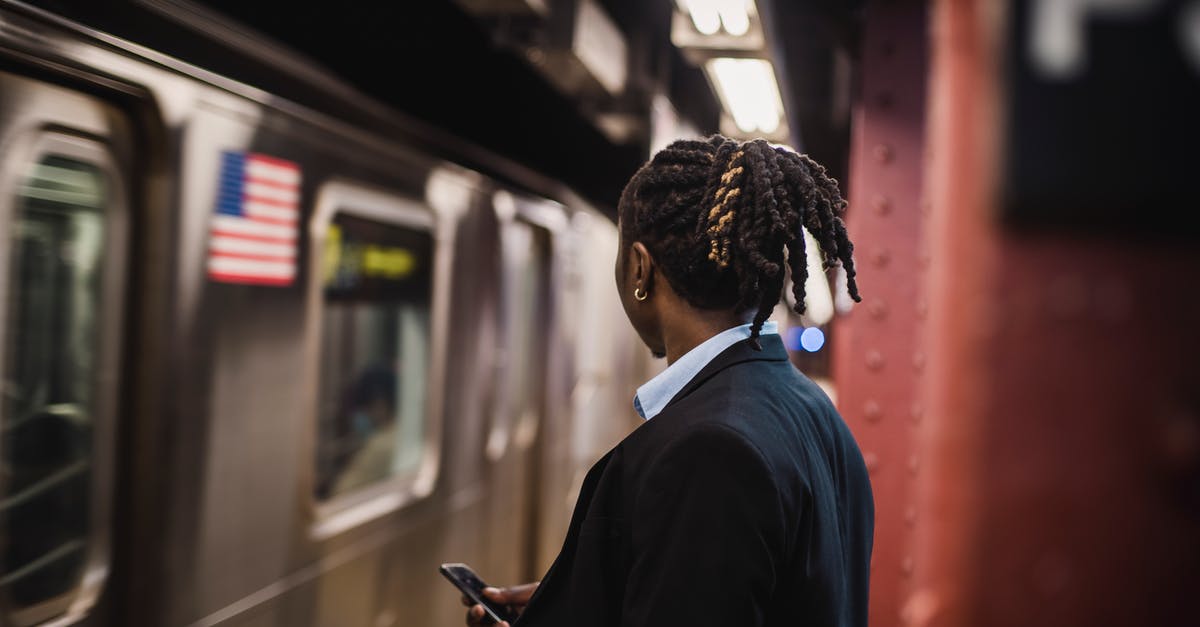 Can an American get a UK Transit Visa on Arrival? - Man in suit looking at arriving train on subway Can an American get a UK Transit Visa on Arrival? - Man in suit looking at arriving train on subway