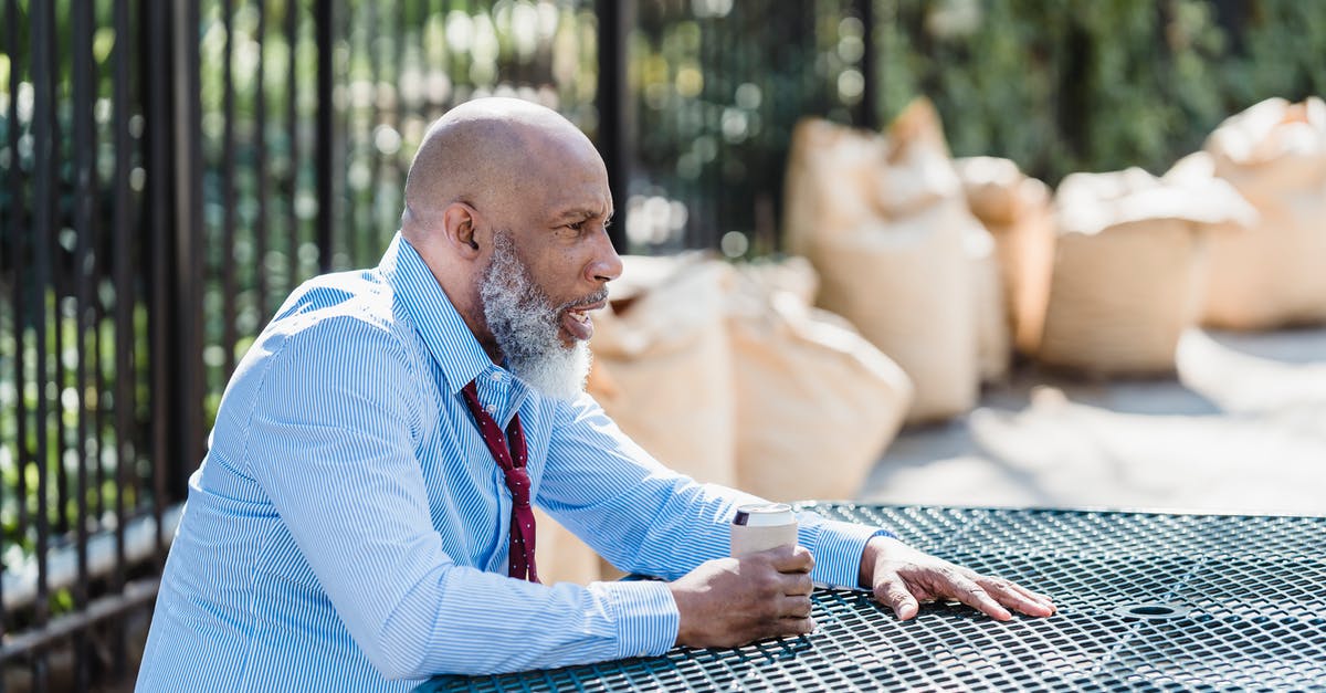 Can departing earlier than scheduled cause problems with UK Immigration? - Side view of concerned African American male entrepreneur in formal clothes with can of alcohol beverage sitting at table on street Can departing earlier than scheduled cause problems with UK Immigration? - Side view of concerned African American male entrepreneur in formal clothes with can of alcohol beverage sitting at table on street