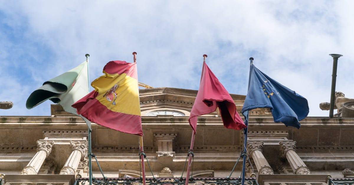 Can EU nationals enter and exit Albania with EU ID card? - Flags waving on old ornate city building on fine day Can EU nationals enter and exit Albania with EU ID card? - Flags waving on old ornate city building on fine day