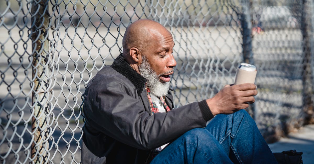 Can growing a beard cause problems in crossing borders? - Hairless black male looking at beer can in hand against mesh fence in daylight Can growing a beard cause problems in crossing borders? - Hairless black male looking at beer can in hand against mesh fence in daylight