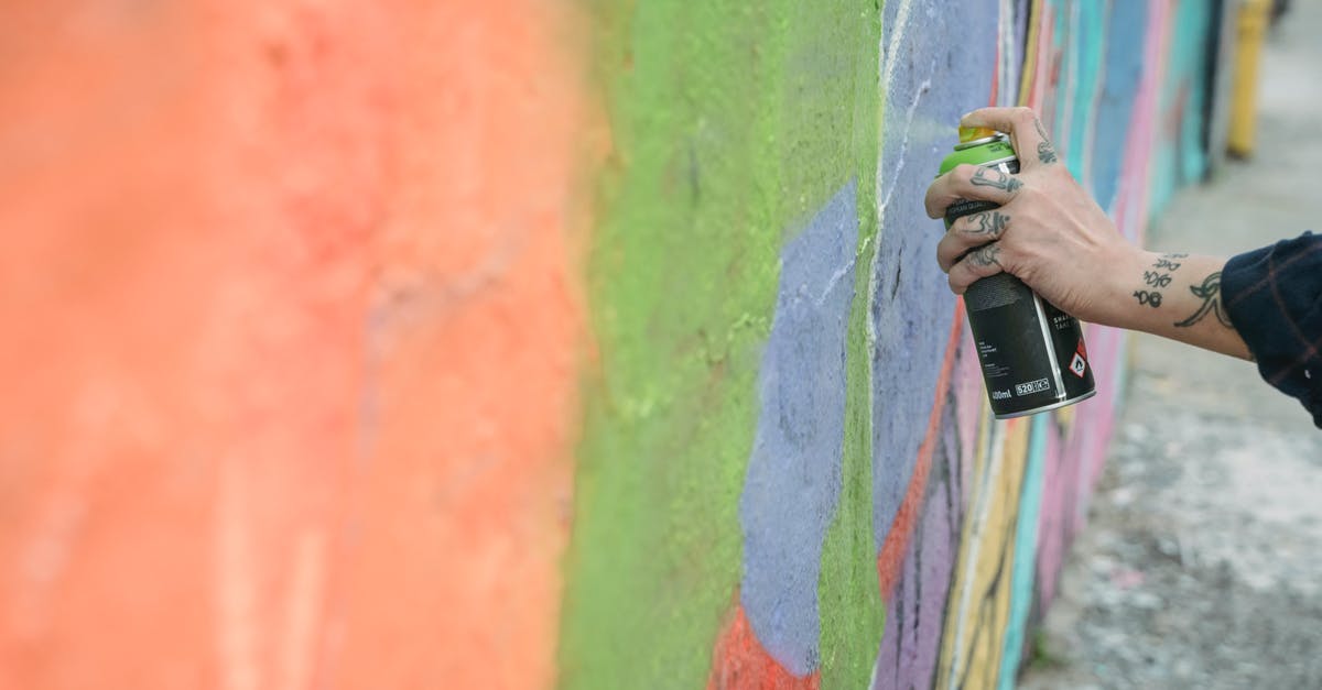 Can I apply for Schengen visa in UK - Anonymous artist painting graffiti on street Can I apply for Schengen visa in UK - Anonymous artist painting graffiti on street