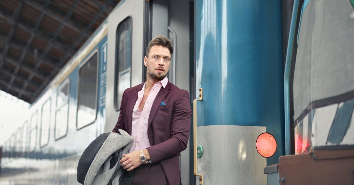 Can I bag wrap my suitcase at Leeds railway station? - Serious bearded male passenger in stylish suit standing near train with travel bag and coat in hand and looking away Can I bag wrap my suitcase at Leeds railway station? - Serious bearded male passenger in stylish suit standing near train with travel bag and coat in hand and looking away