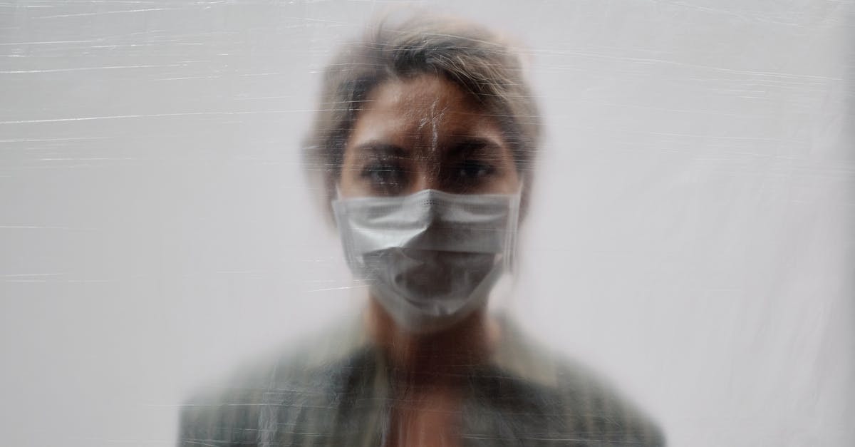 Can I bring gold sheet face masks in my carry on? - Woman in Striped Green Top and Face Mask Behind a Translucent Sheet Can I bring gold sheet face masks in my carry on? - Woman in Striped Green Top and Face Mask Behind a Translucent Sheet