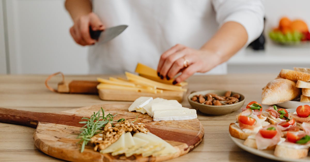 Can I bring one wooden chopping board into USA in checked in bag? - Person Slicing Cheese on Brown Wooden Chopping Board