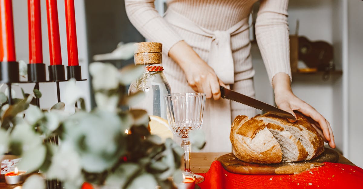 Can I bring one wooden chopping board into USA in checked in bag? - A Woman Slicing a Loaf of Bread on a Chopping Board