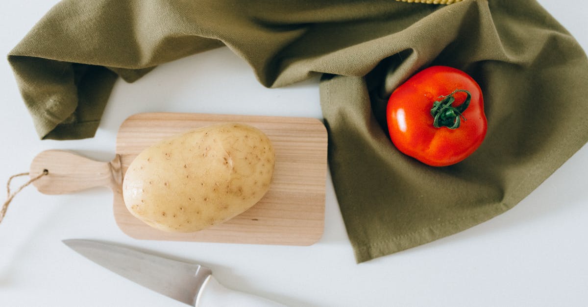 Can I bring one wooden chopping board into USA in checked in bag? - A Potato on a Wooden Chopping Board Beside a Tomato and Corn