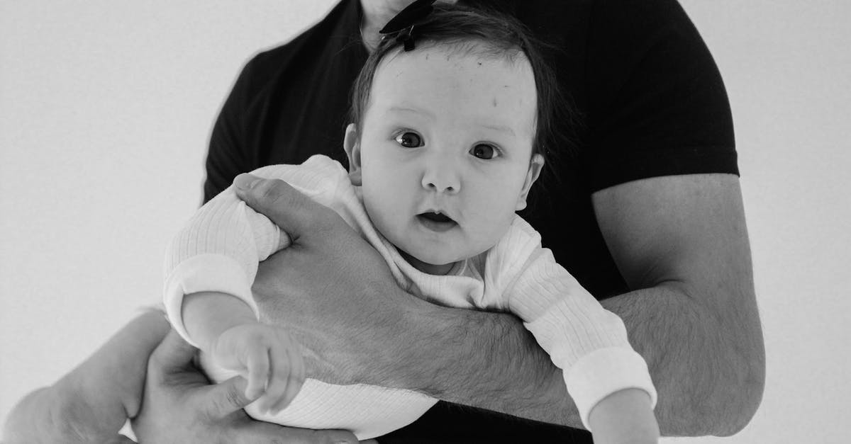 Can I buy a child ticket for my infant baby? - Man in Black T-shirt Carrying Baby in White Onesie Can I buy a child ticket for my infant baby? - Man in Black T-shirt Carrying Baby in White Onesie