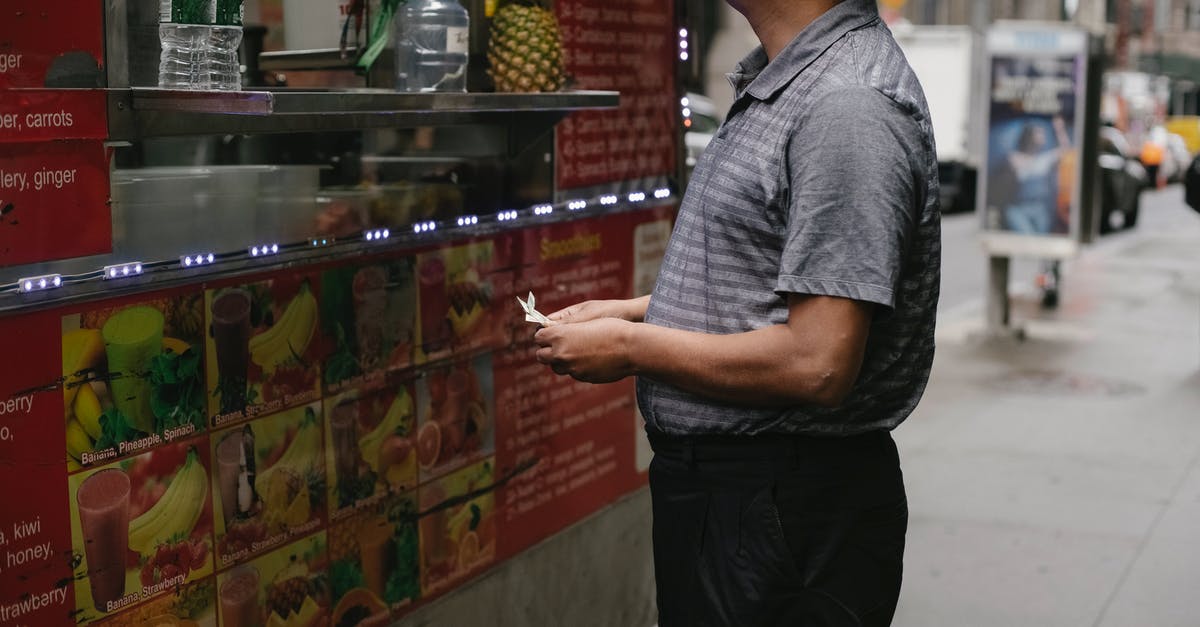 Can I buy an airline ticket, go thru immigration, buy duty free then walk out of the airport? - Side view of tranquil man with banknotes buying street food at food truck with fruits on street in town Can I buy an airline ticket, go thru immigration, buy duty free then walk out of the airport? - Side view of tranquil man with banknotes buying street food at food truck with fruits on street in town