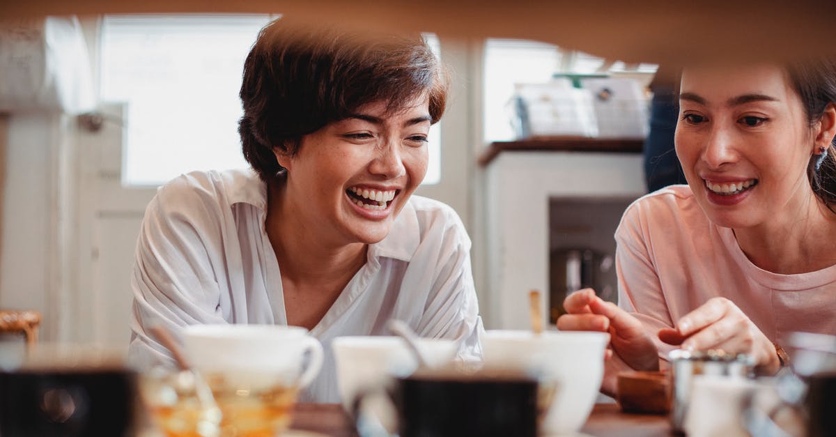 Can I buy another set of round trip tickets if I already have one for a later date? - Happy young ethnic ladies having fun in store near table with dishware