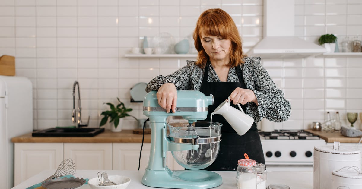 Can I buy pressure cookers and mixer grinders in Poland? - Woman in Black and White Long Sleeve Shirt Pouring Water on Clear Glass Pitcher Can I buy pressure cookers and mixer grinders in Poland? - Woman in Black and White Long Sleeve Shirt Pouring Water on Clear Glass Pitcher