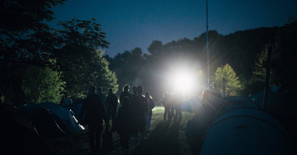 Can I camp on a campsite under 18 in Italy? - People Standing Near Tent during Night Time Can I camp on a campsite under 18 in Italy? - People Standing Near Tent during Night Time