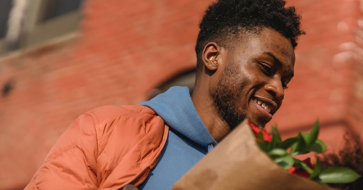 Can I carry a watch as a gift in my carry-on luggage when flying from Kolkata to Chennai? [duplicate] - From below of young African American male in stylish outfit carrying flowers wrapped in craft paper on street looking away