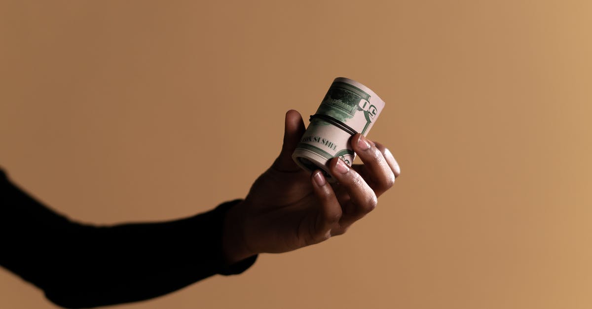 Can I carry large sum of cash (>10k EUR) in my hand luggage? - Person Holding White and Green Plastic Bottle