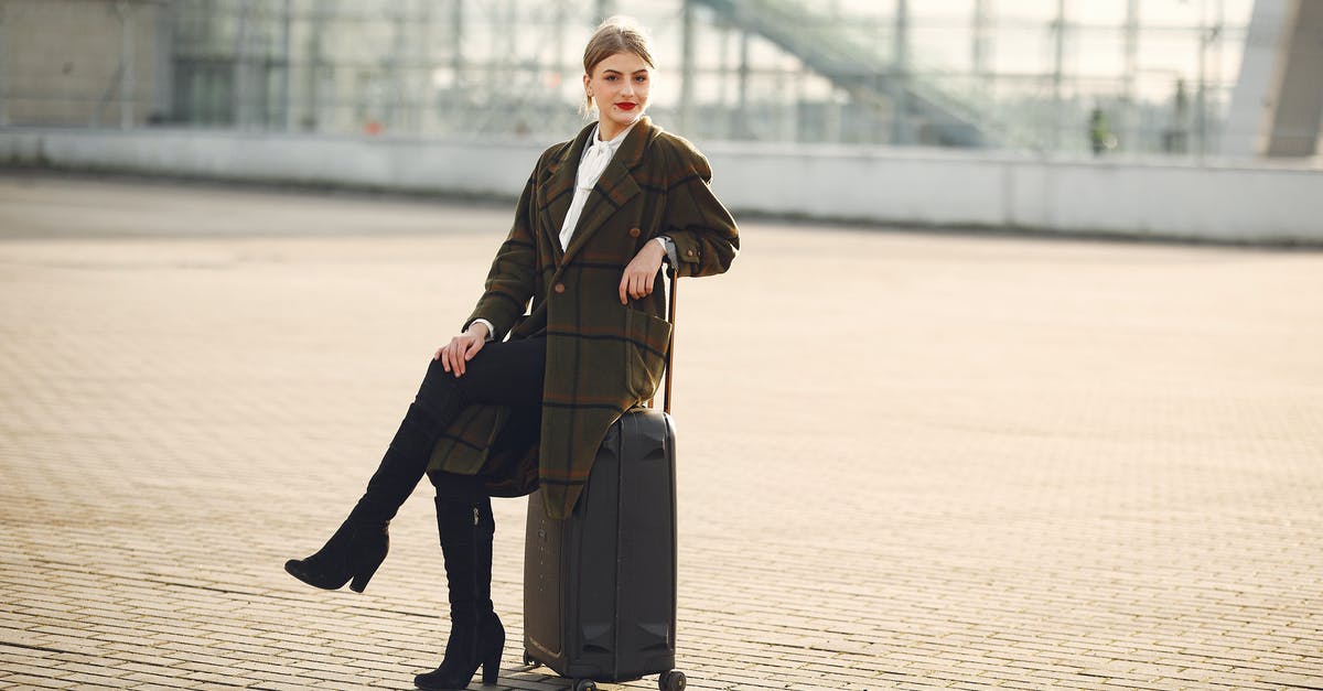 Can I claim my luggage if I am forced to stop after only the first leg of my journey - Full length of positive female traveler wearing warm trendy plaid coat and high boots sitting on suitcase with legs crossed on pavement near modern airport terminal and smiling looking at camera in daylight during cold season Can I claim my luggage if I am forced to stop after only the first leg of my journey - Full length of positive female traveler wearing warm trendy plaid coat and high boots sitting on suitcase with legs crossed on pavement near modern airport terminal and smiling looking at camera in daylight during cold season