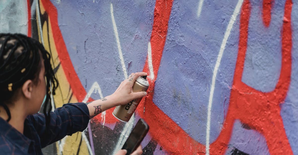 Can I consign my pepper spray from Canada to China? - From above side view of crop faceless female artist with braided hair painting graffiti on wall while standing on street Can I consign my pepper spray from Canada to China? - From above side view of crop faceless female artist with braided hair painting graffiti on wall while standing on street