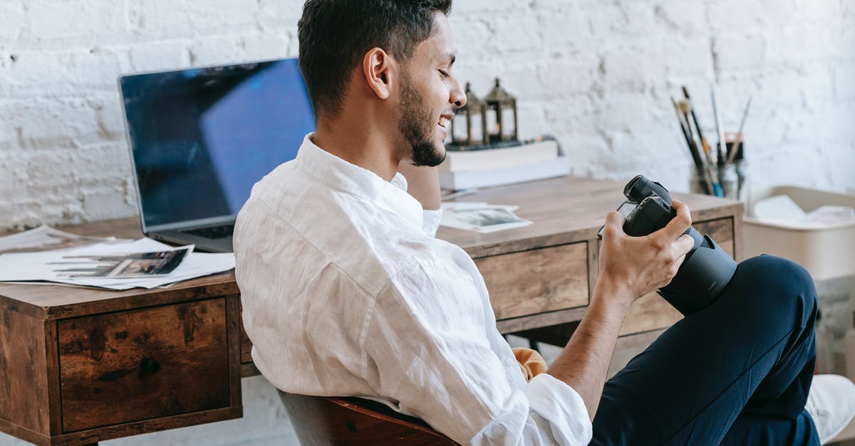 Can I cross the border into Canada using my birth certificate and a photo ID? - Cheerful ethnic man using photo camera in light office Can I cross the border into Canada using my birth certificate and a photo ID? - Cheerful ethnic man using photo camera in light office