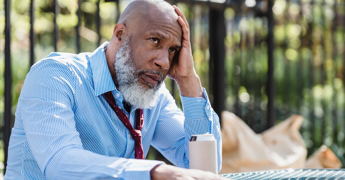 Can I do a break-of-journey on Thalys? - Thoughtful African American man sitting at table with tin can Can I do a break-of-journey on Thalys? - Thoughtful African American man sitting at table with tin can