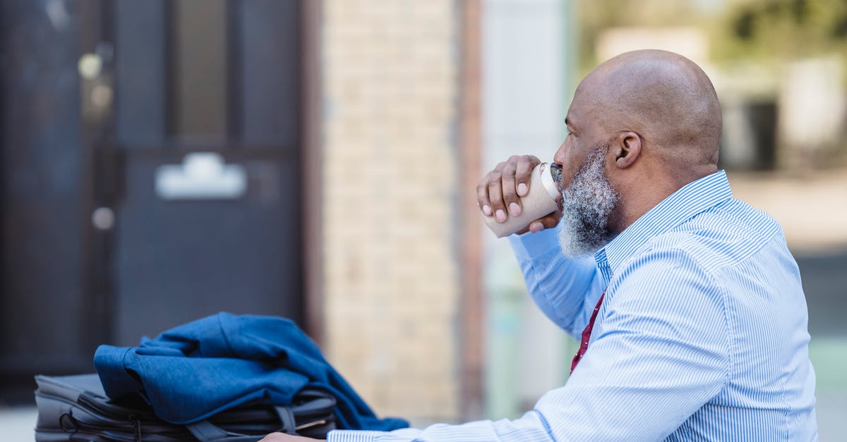 Can I do six months in the USA on the VWP with a two week break in between? - Side view of elderly bearded African American man in trendy outfit sitting at table with jacket and handbag and drinking beverage from tin can in veranda of cafe
