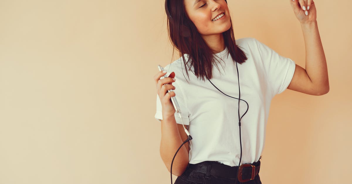 Can I enter Oman twice in a short period of time, using a visa-on-arrival? [closed] - Happy young female in casual clothes smiling and dancing with eyes closed while listening to good music in headphones in studio on beige background