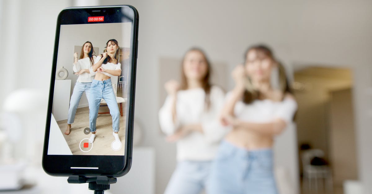Can I enter the US under VWP / B-1 as a social media influencer to model for a fashion campaign? - Woman in White Sleeveless Shirt and Blue Denim Skirt Holding Black Smartphone