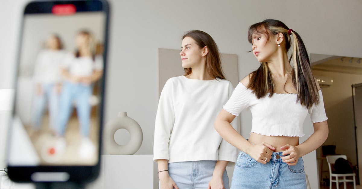 Can I enter the US under VWP / B-1 as a social media influencer to model for a fashion campaign? - Woman in White Long Sleeve Shirt and Blue Denim Jeans Standing Beside Woman in White Long